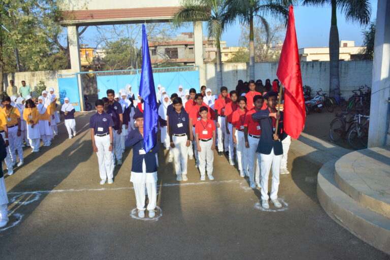 A girl and a boy holding their house color flag on sports day at Shahbaaz school and PU college