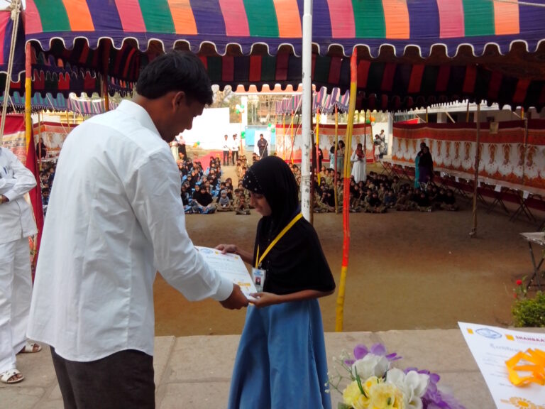 A girl taking her medal during science exhibition at Shahbaaz school and Pu college