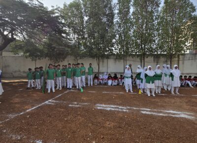 House Green Sports Representatives in the Shahbaaz school playground behind the school building.